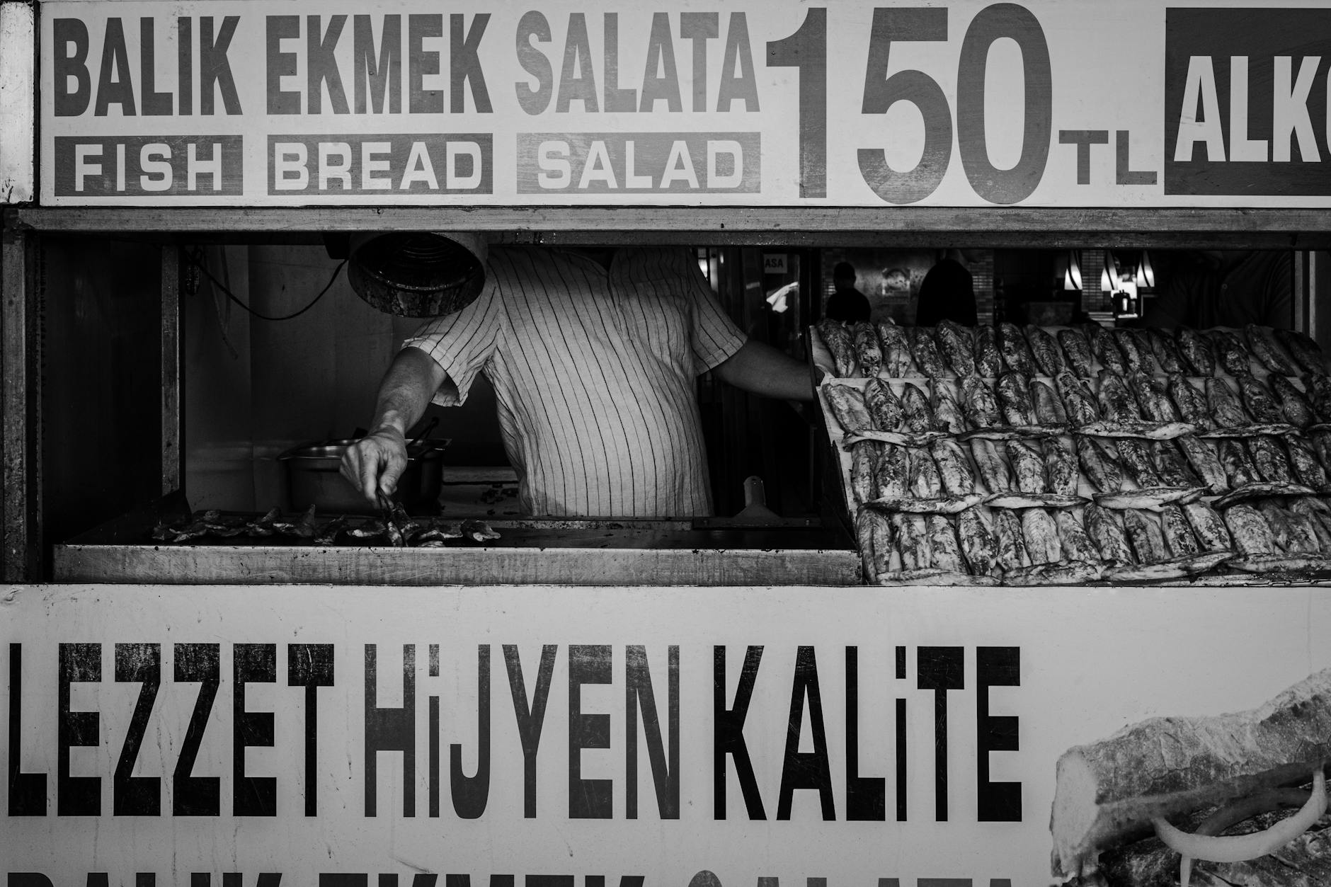 サバサンドの価格と品質を掲げるモノクロの屋台風景。