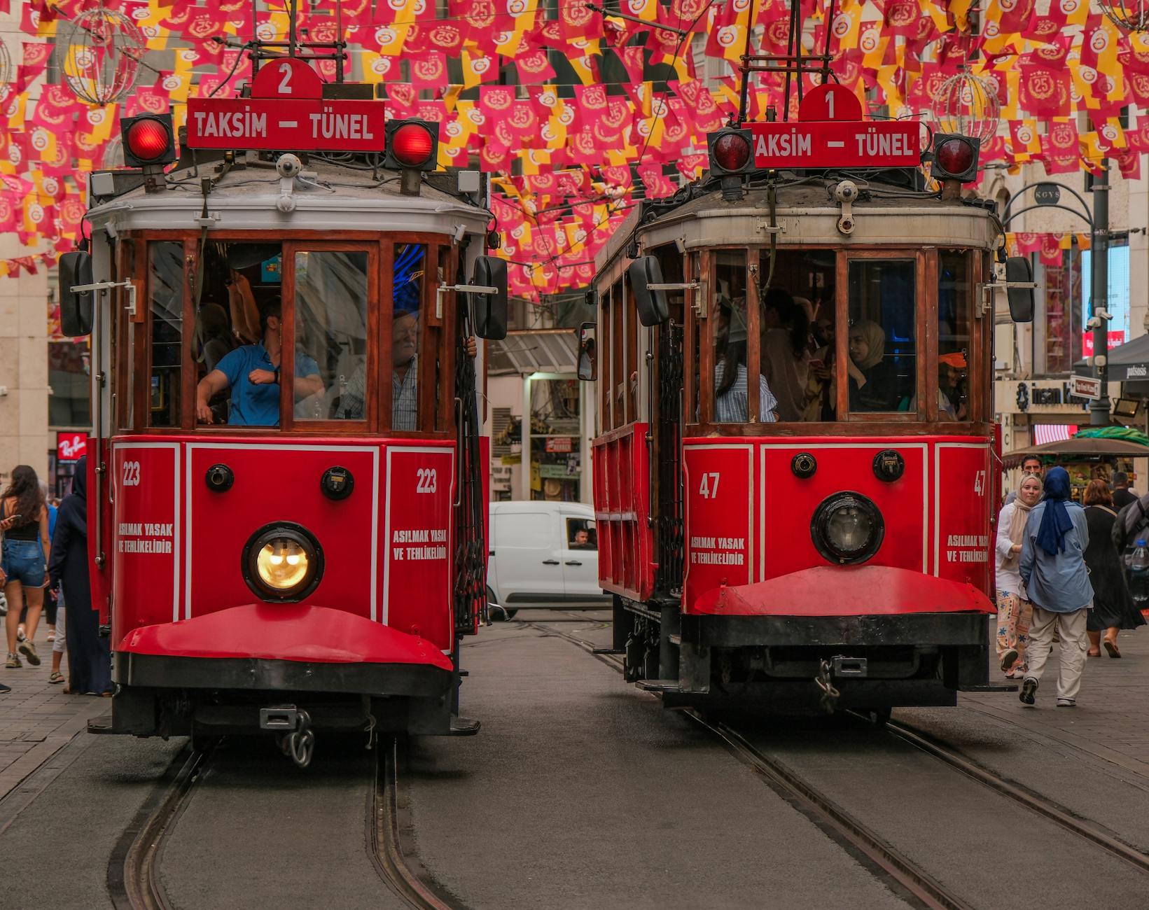 観光客に人気のイスティクラル通りを走る二台の赤いレトロな路面電車。