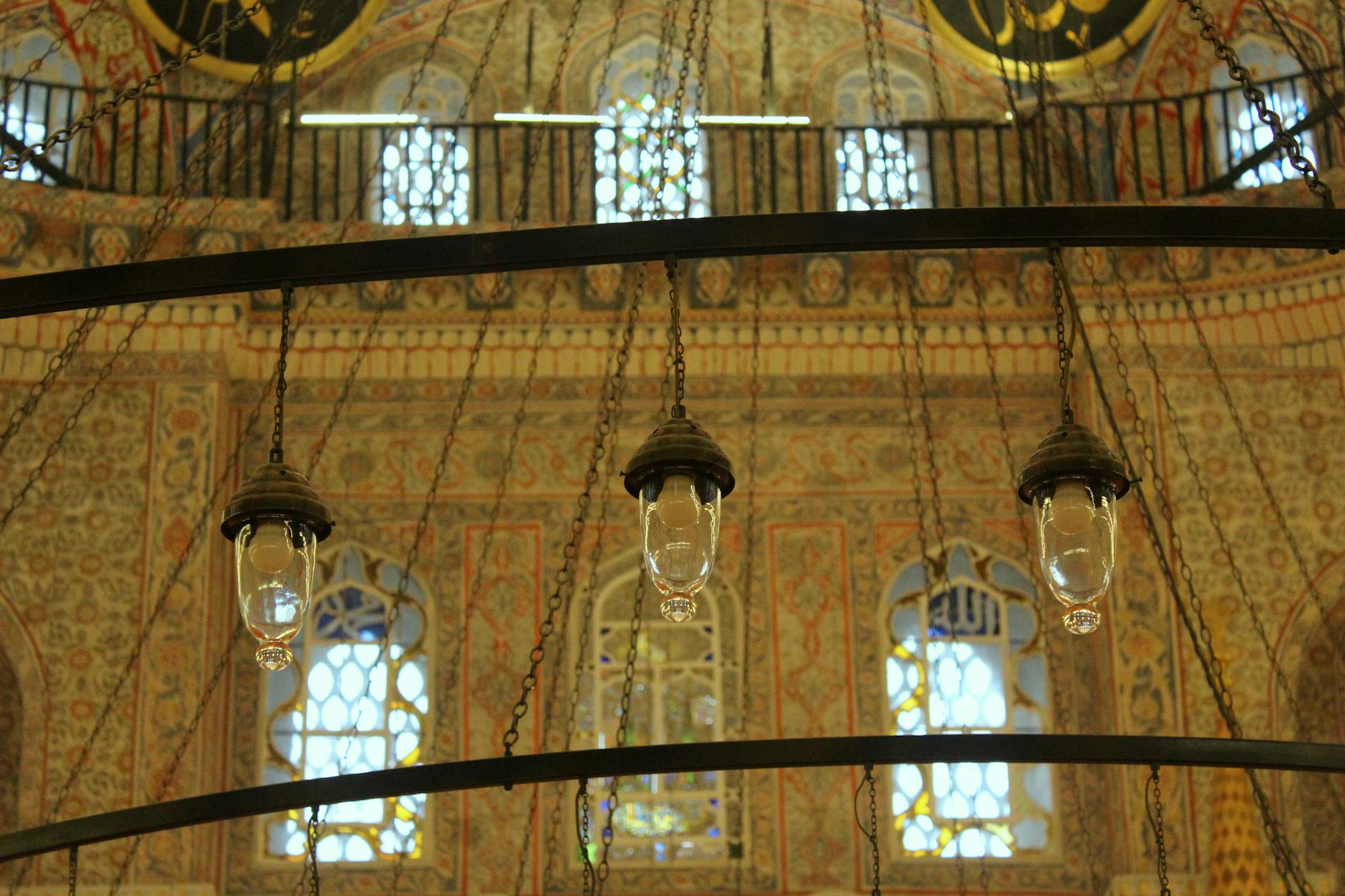 モスク内部を照らすシャンデリアと壁面の美しい装飾ディテール。