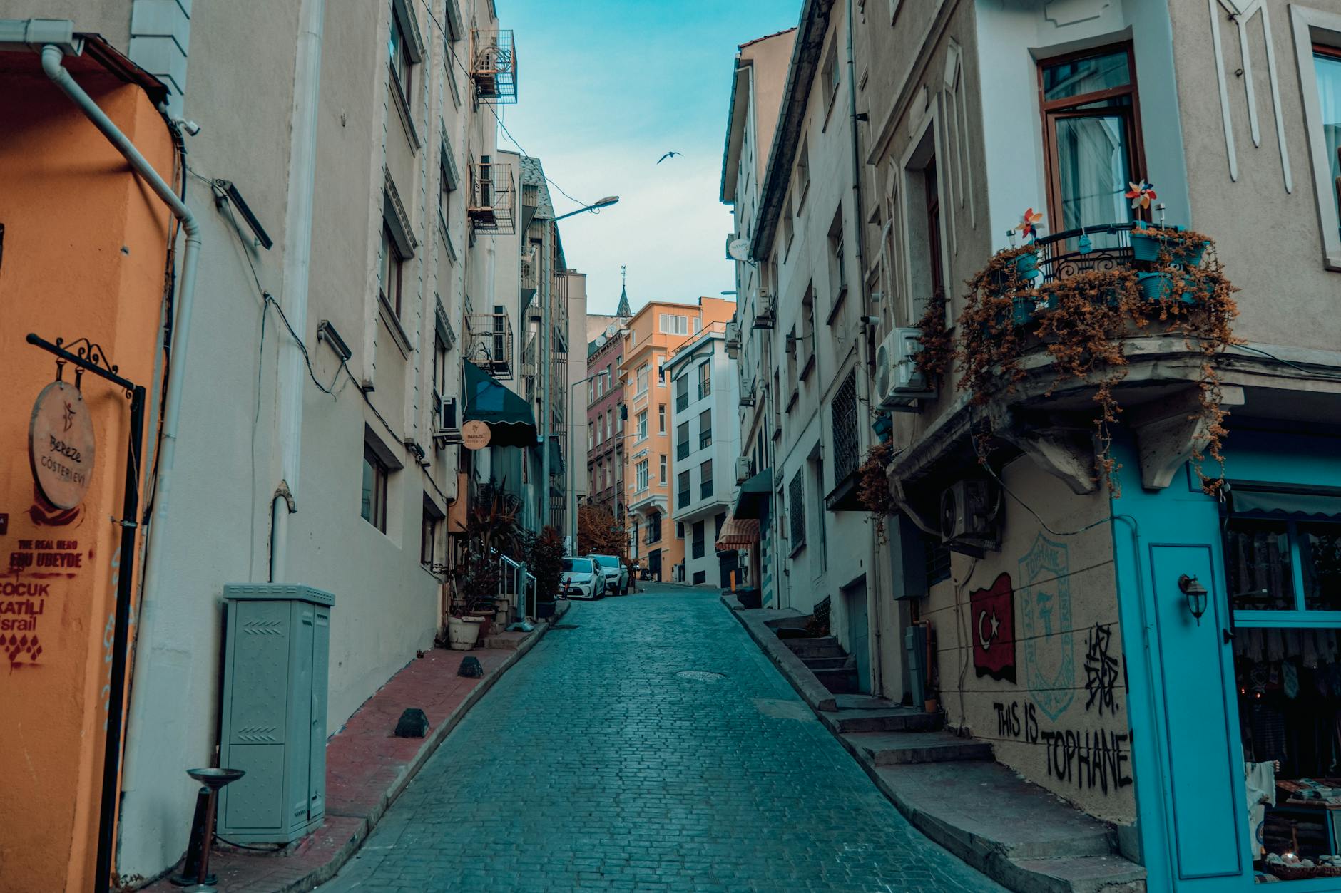 トプハネ地区の趣ある石畳の坂道と建物の壁に描かれたグラフィティ。